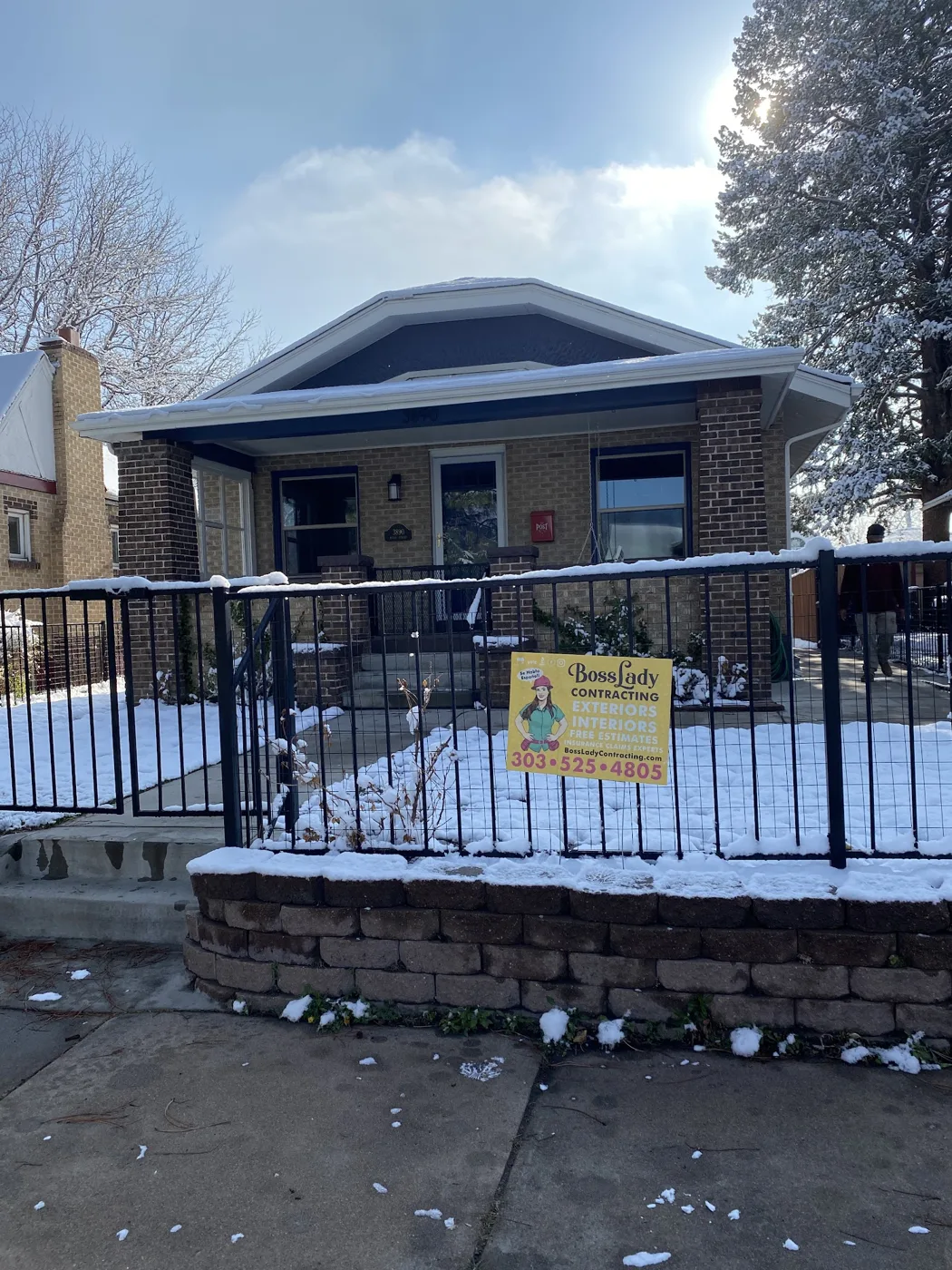 Denver brick bungalow with a new black metal railing and front deck by BossLady Contracting